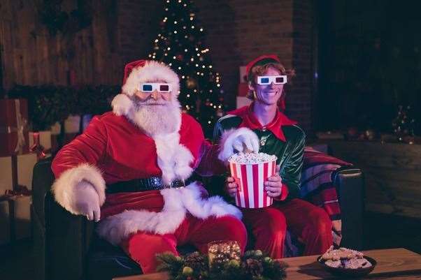 Santa and an elf enjoy a movie night.