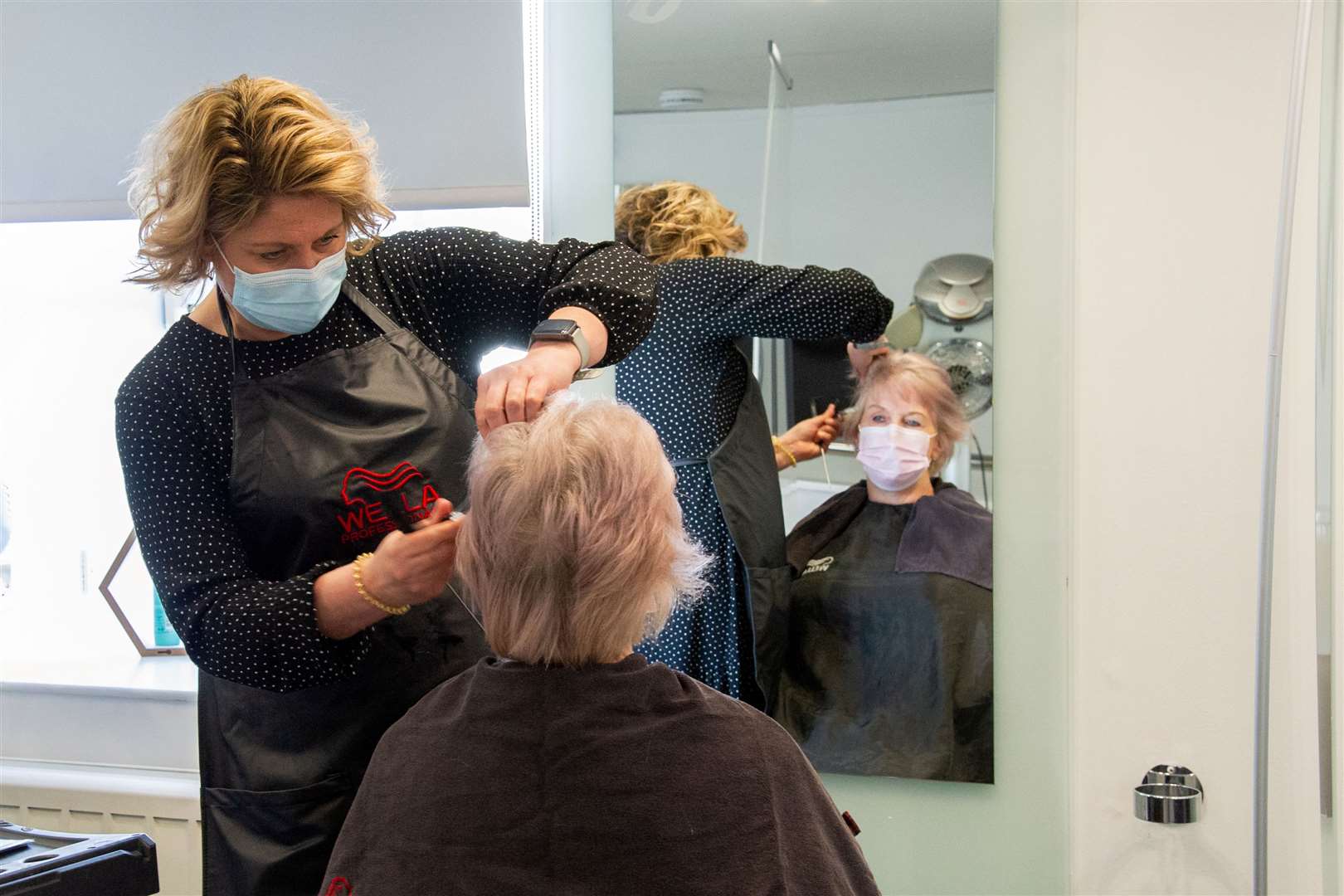 Weir Hairdressing co-owner Moira Mulloy works on nurse Edith Campbell's hair. Picture: Daniel Forsyth