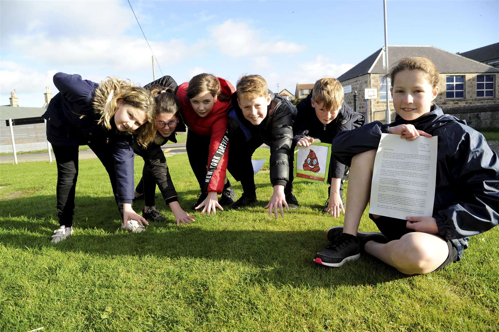 Marina Wallace (right) pictured here with her letter to the community, is joined by classmates in reinforcing the Pick It Up, Bag It, Bin It message. Picture: Eric Cormack