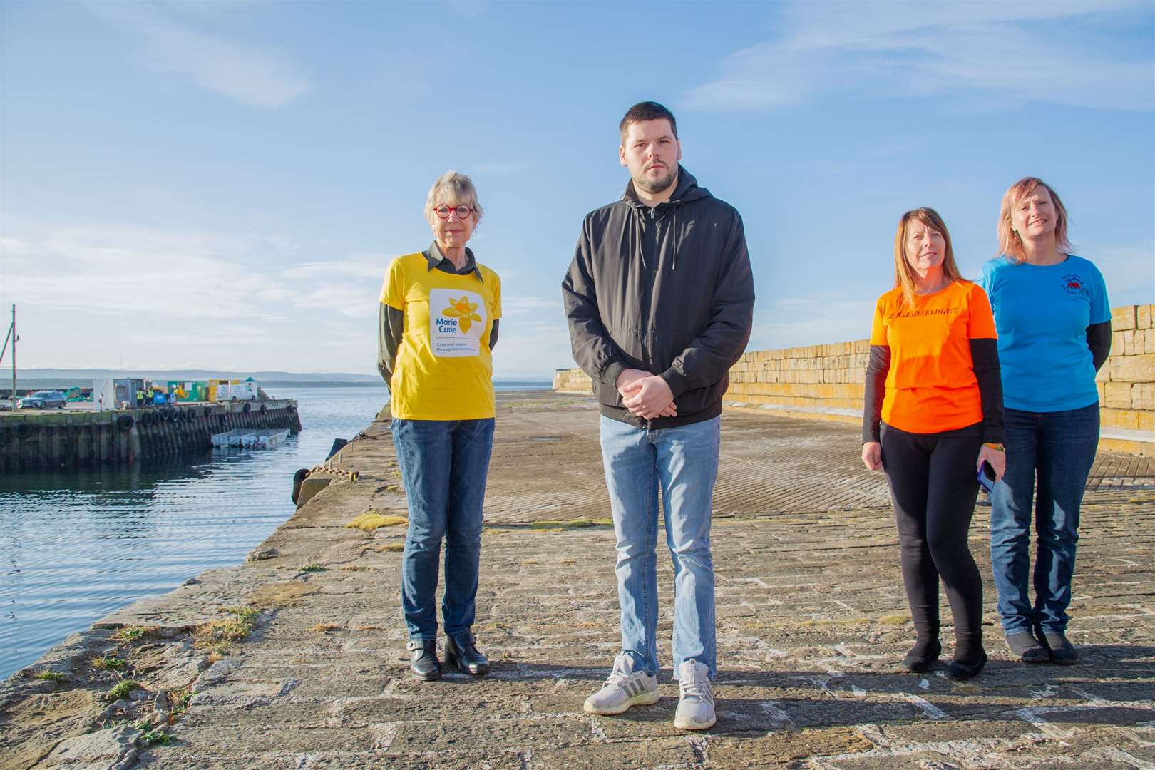 Jamie Campbell, the Burghead Boxing Day Swim's president, is joined by charity representatives. Photo taken prior to lockdown, pre-swim. Picture: Daniel Forsyth