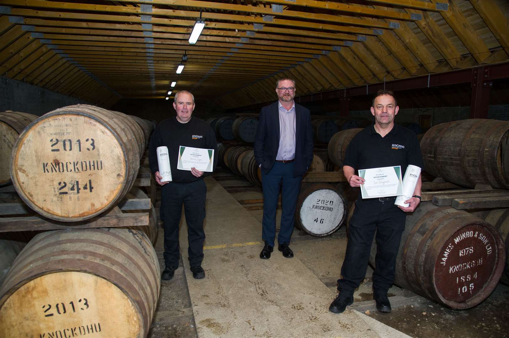 James Logie, left, and Ian Dingwall who were honoured for 30 years at Knockdhu Distillery with Derek Sinclair, centre who retired as general manager. Picture: Becky Saunderson.