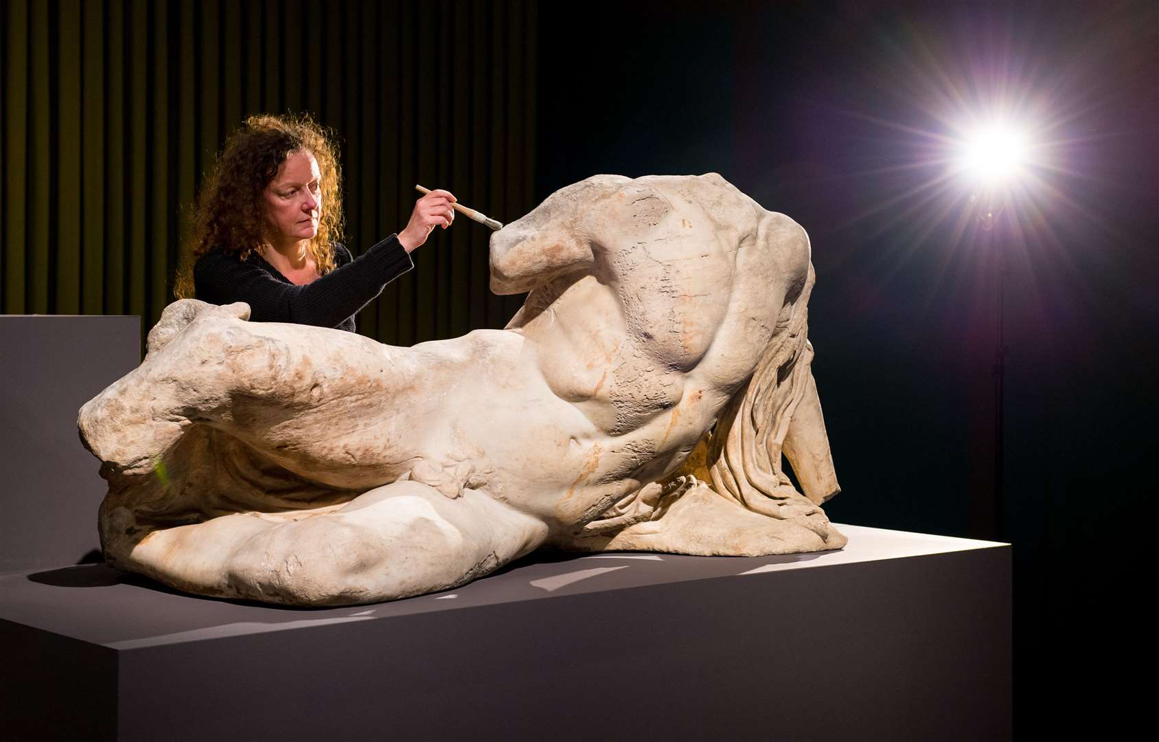 Senior conservator Karen Birkhoelzer is seen with the sculpture The River God Ilissos by Phidias, part of the so-called Elgin marbles (Dominic Lipinski/PA)