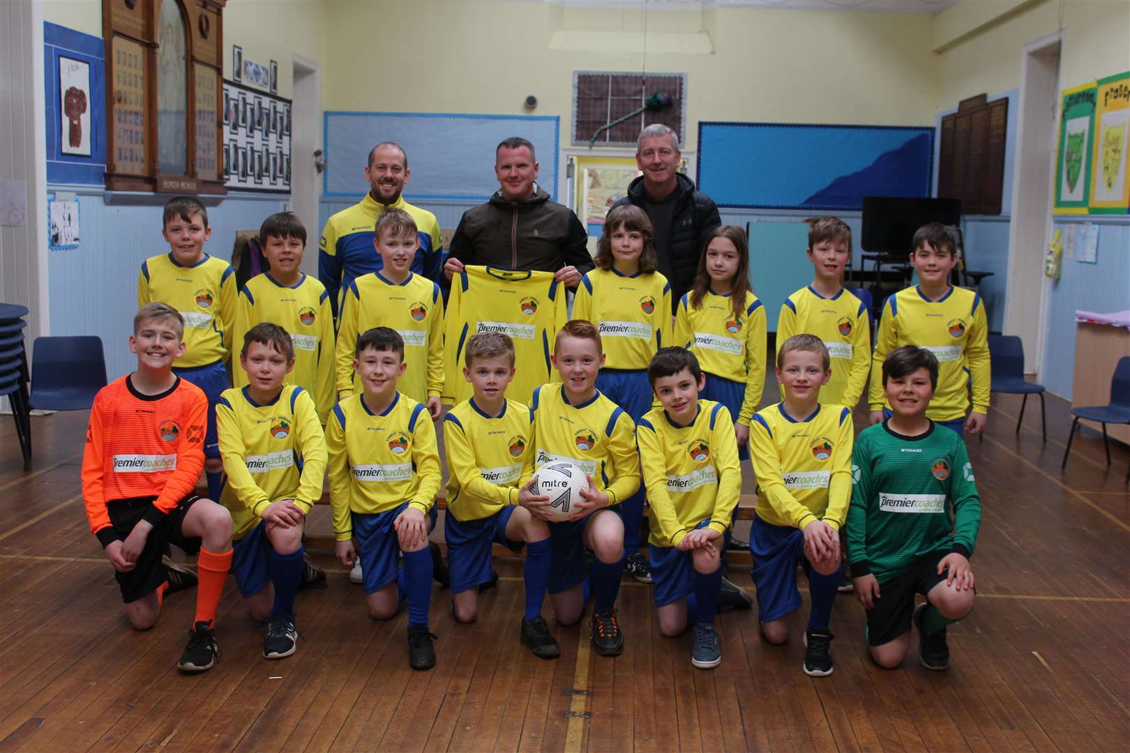 Kemnay Primary School pupils show off their new kits, with head teacher David Williams, Premier Coaches' managing director Alan Findlater and Premier Coaches' business manager David McDonald . Picture: Kirsty Brown