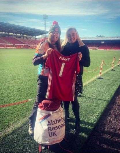 Karen Penny receives a shirt from Chloe Cruden, sales executive at Aberdeen FC.