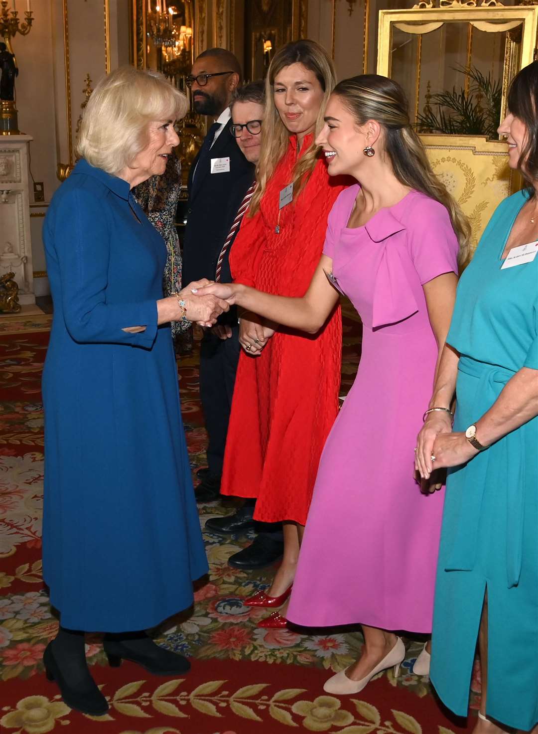 Camilla shakes hands with Zara McDermott at the reception (Eamonn M McCormack/PA)