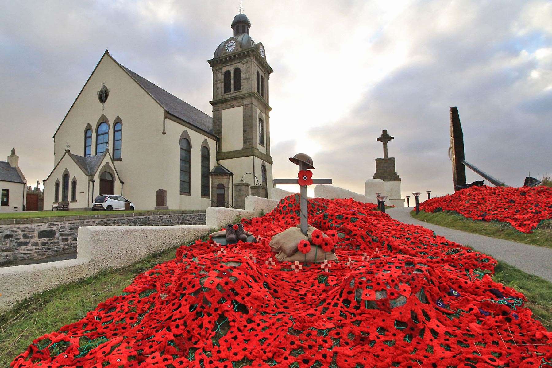 Macduff's tribute for Remembrance is a cascade of poppies in front of the Parish Church at the town cross and anchor, which includes a soldier's helmet on a cross and knitted boots. Picture: Andrew Taylor