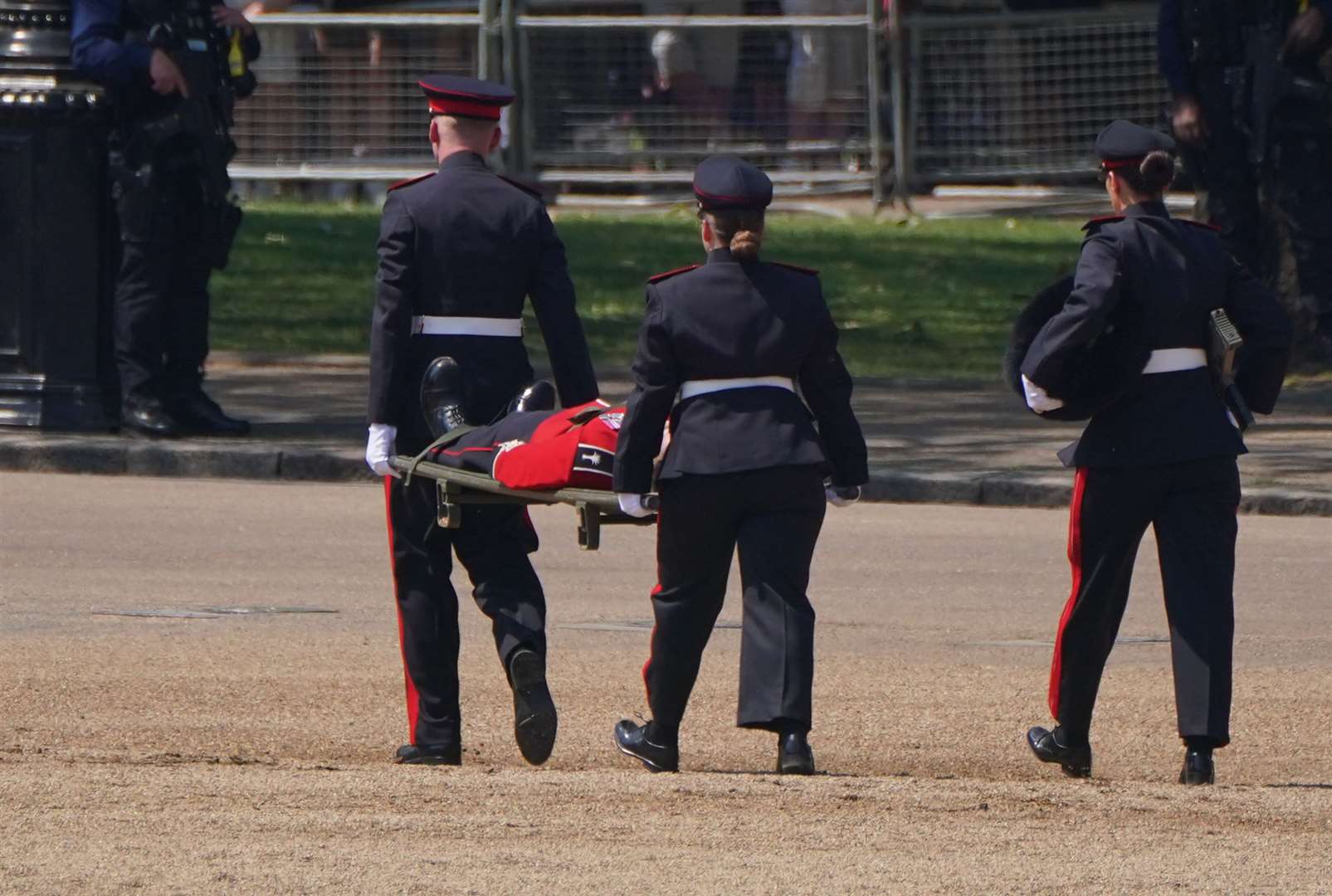 A member of the military is taken by stretcher from the parade ground (Jonathan Brady/PA)