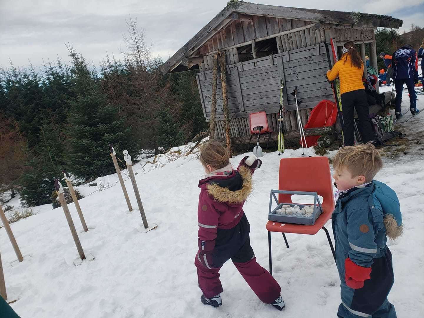 Youngsters attempt to knock snowmen off their perches with snowballs.