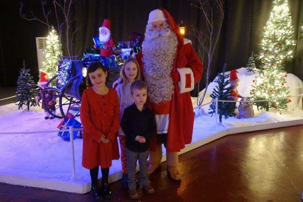 Santa welcomes (l-r) Grace Ross, Holly Ridell and Finlay Ross to his Christmas den at Grampian Transport museum