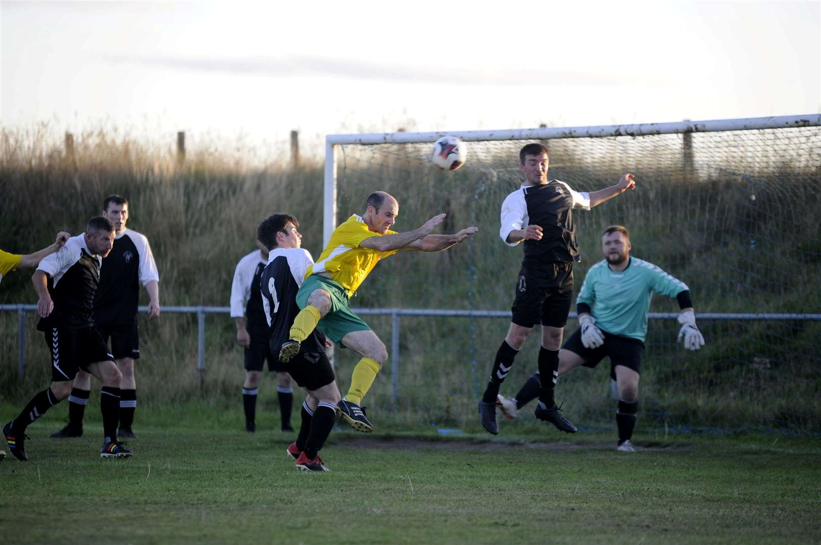 Hopeman's Gary Burr is surrounded by Buckie United players as he tries to win this header..Picture: Becky Saunderson..