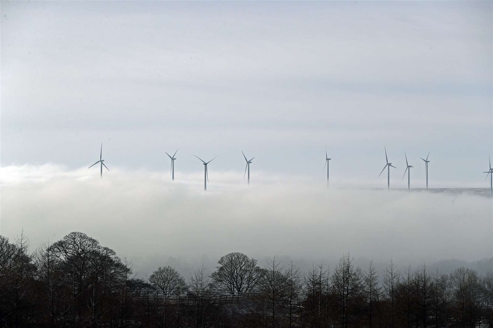 Wind turbines peak out of the top of low-lying clouds over Lancashire (Peter Byrne/PA)