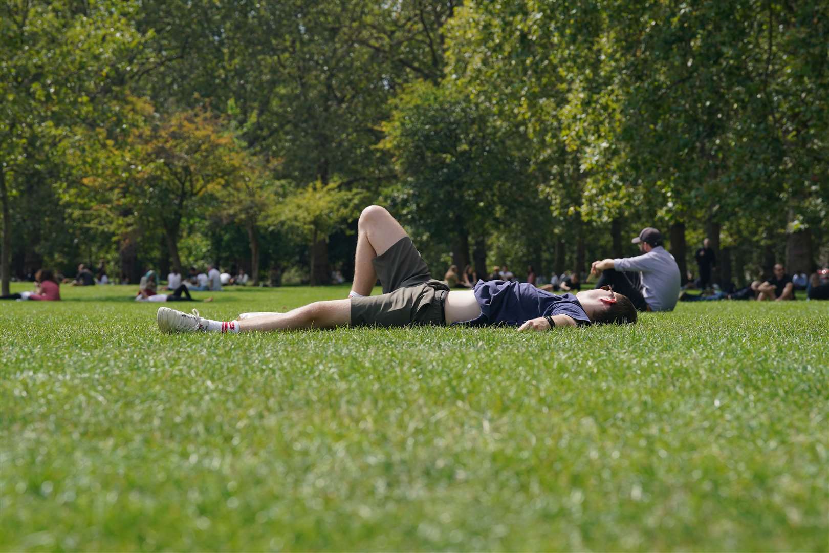 People relax in Green Park, London, during warm weather (Lucy North/PA)