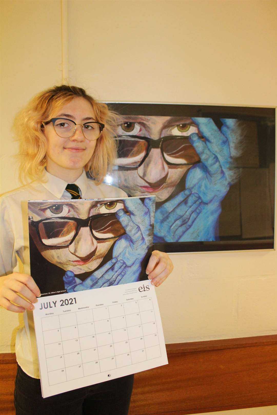 Hazel Sherman proudly shows off her artwork in the EIS calendar.