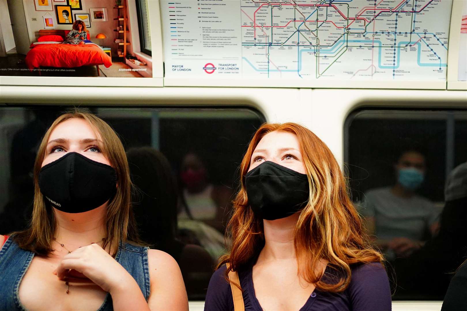 Two women wearing facemasks on a Tube train (Victoria Jones/PA)