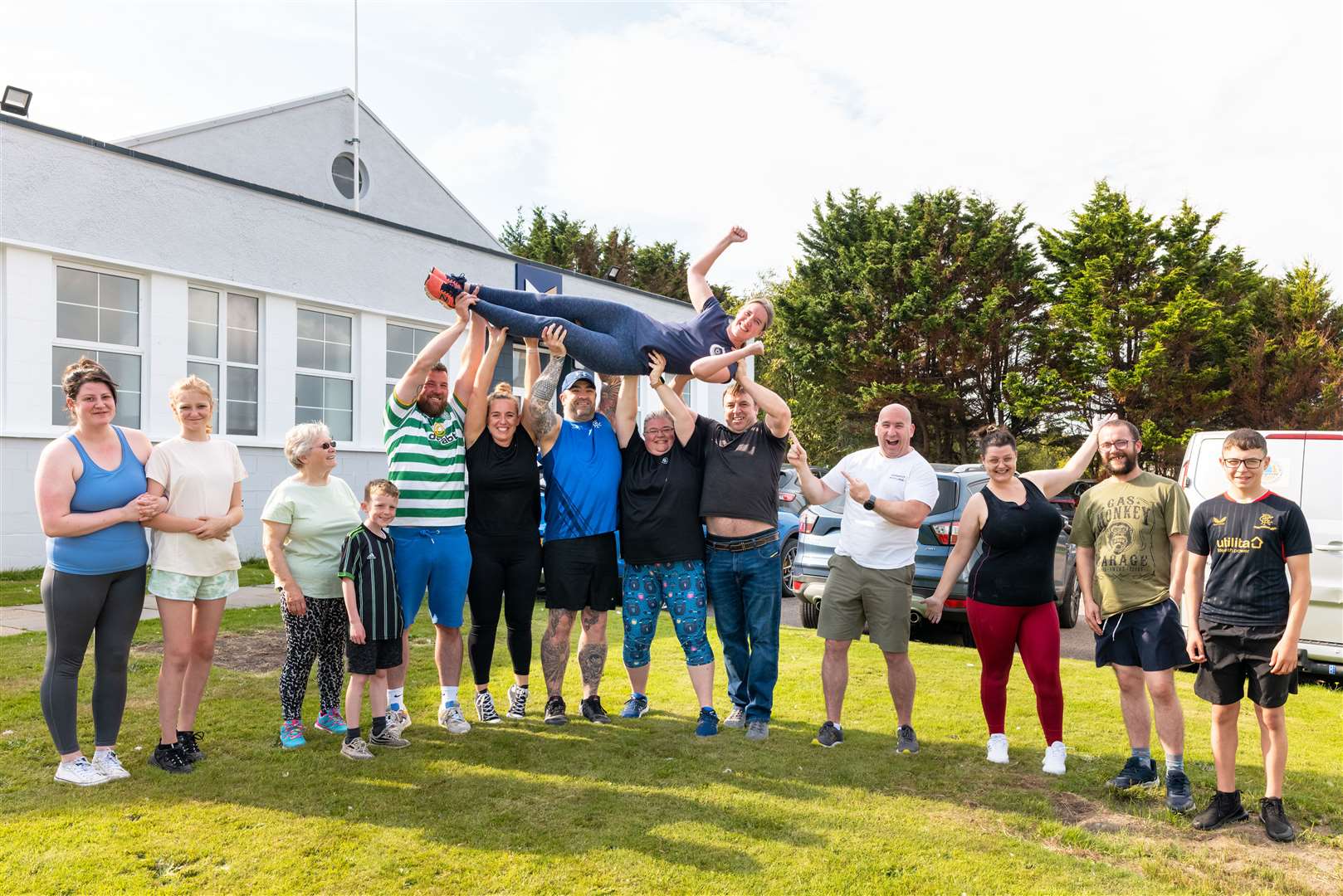 Helen Wishart is held aloft at the end of the challenge by gym members, joined by husband Graeme (fourth right). Picture: Jasper Image