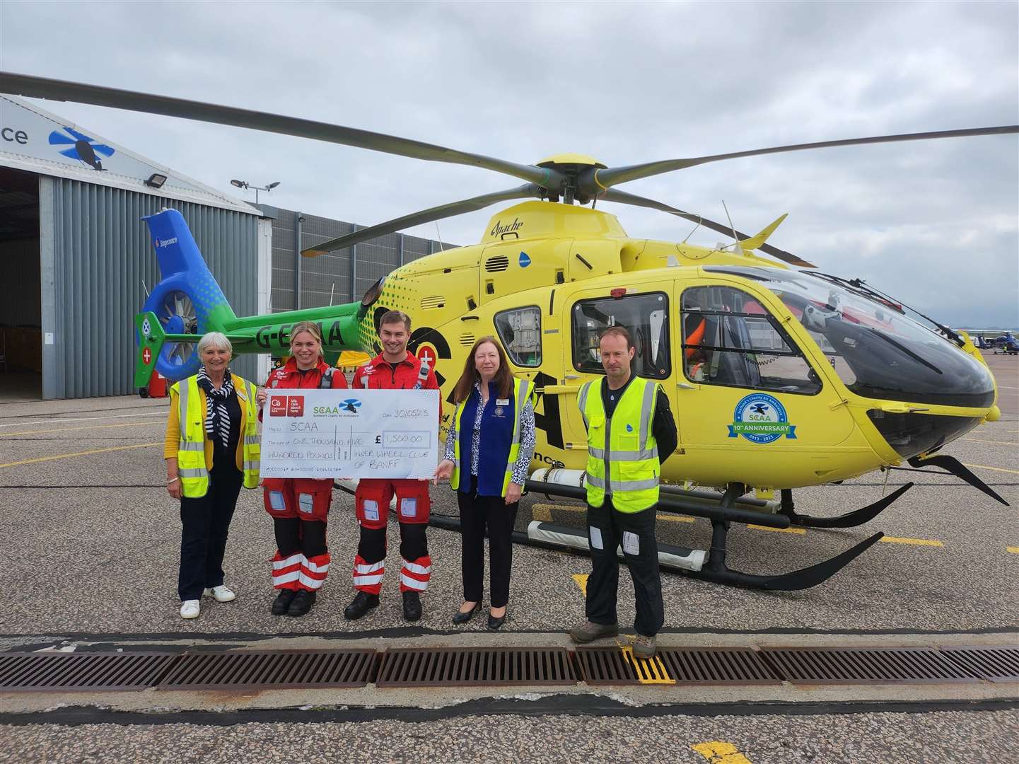 Inner Wheel Club of Banff president Teresa Ruparelia and Sandra Leith present the donation to the Scottish Charity Air Ambulance helicopter crew.
