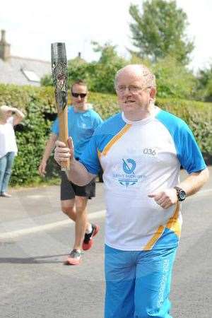 Ken carries the Queen's baton through Mosstodloch in 2014. Picture: Eric Cormack