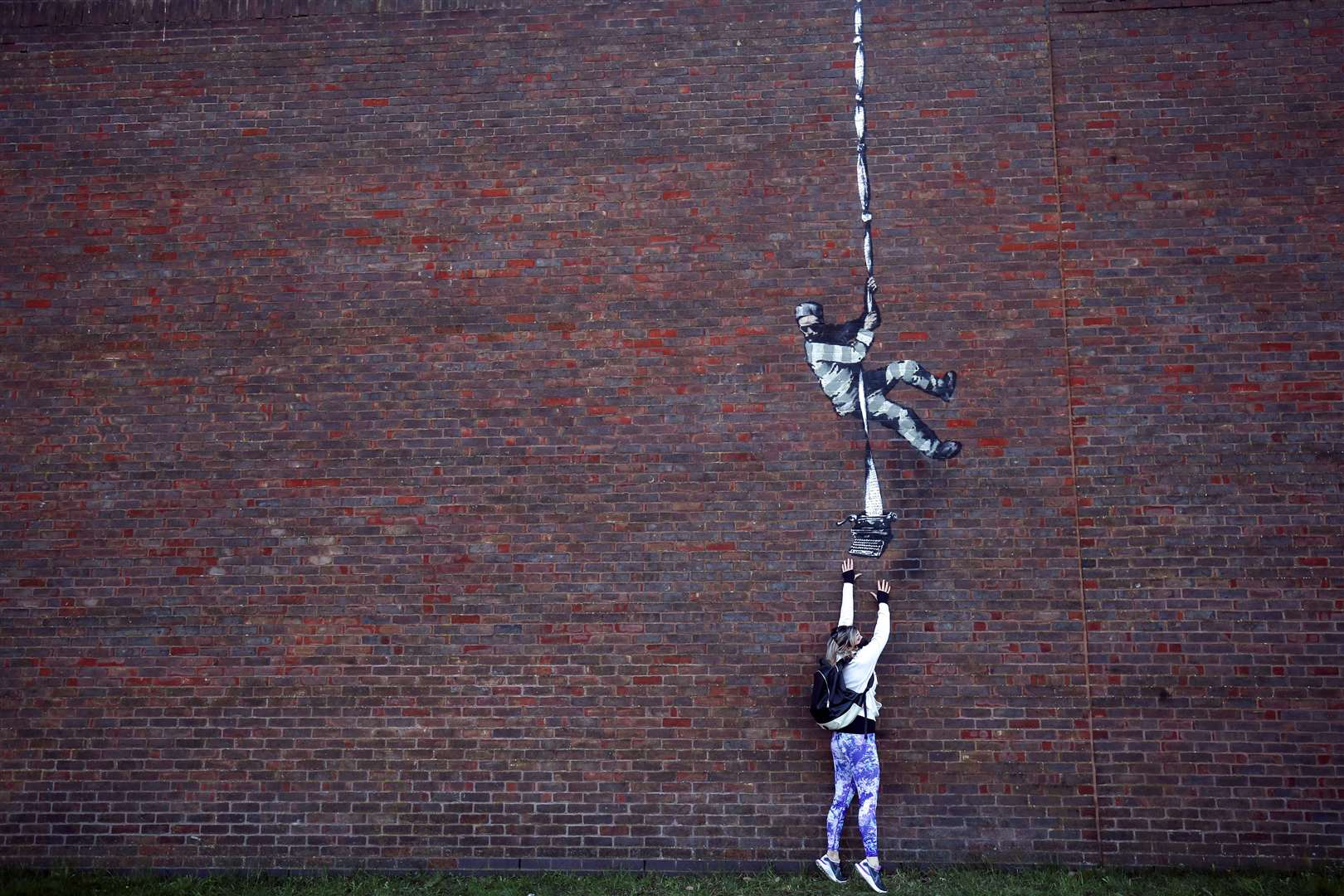A member of the public looks at an artwork on the wall of the former prison in Reading (Steve Parsons/PA)