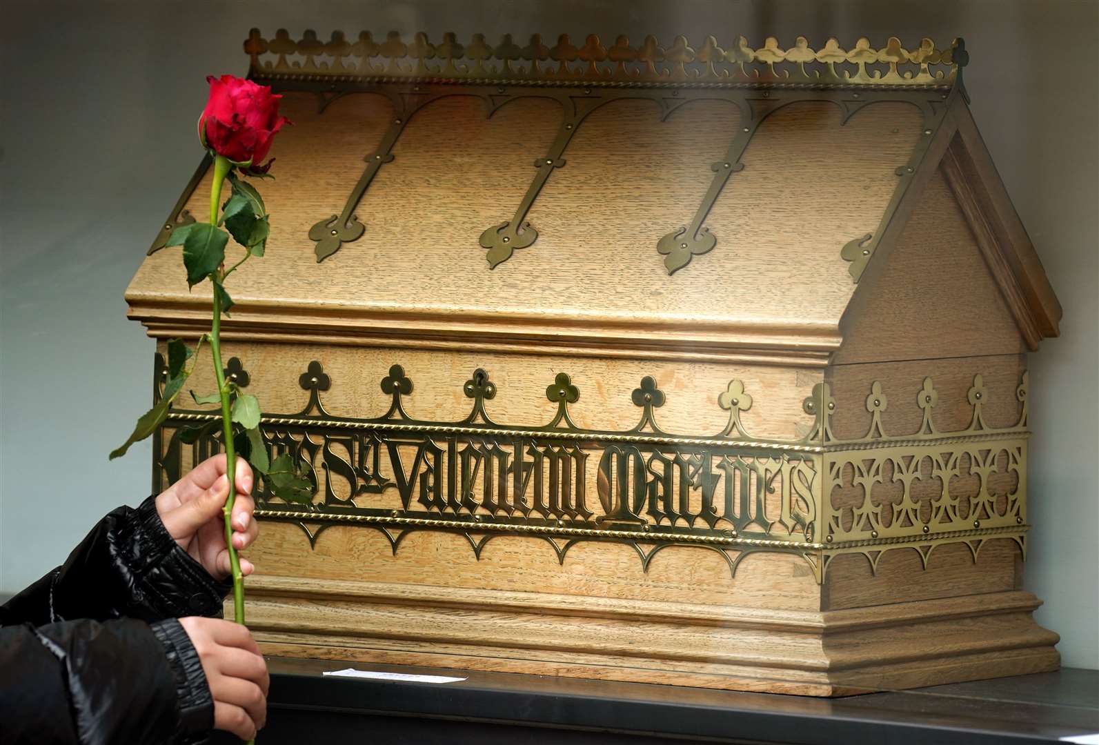 Visitor Yuki Fan holds a rose beside the chest containing bones belonging to St Valentine at the Blessed John Duns Scotus church in the Gorbals, Glasgow (Andrew Milligan/PA)