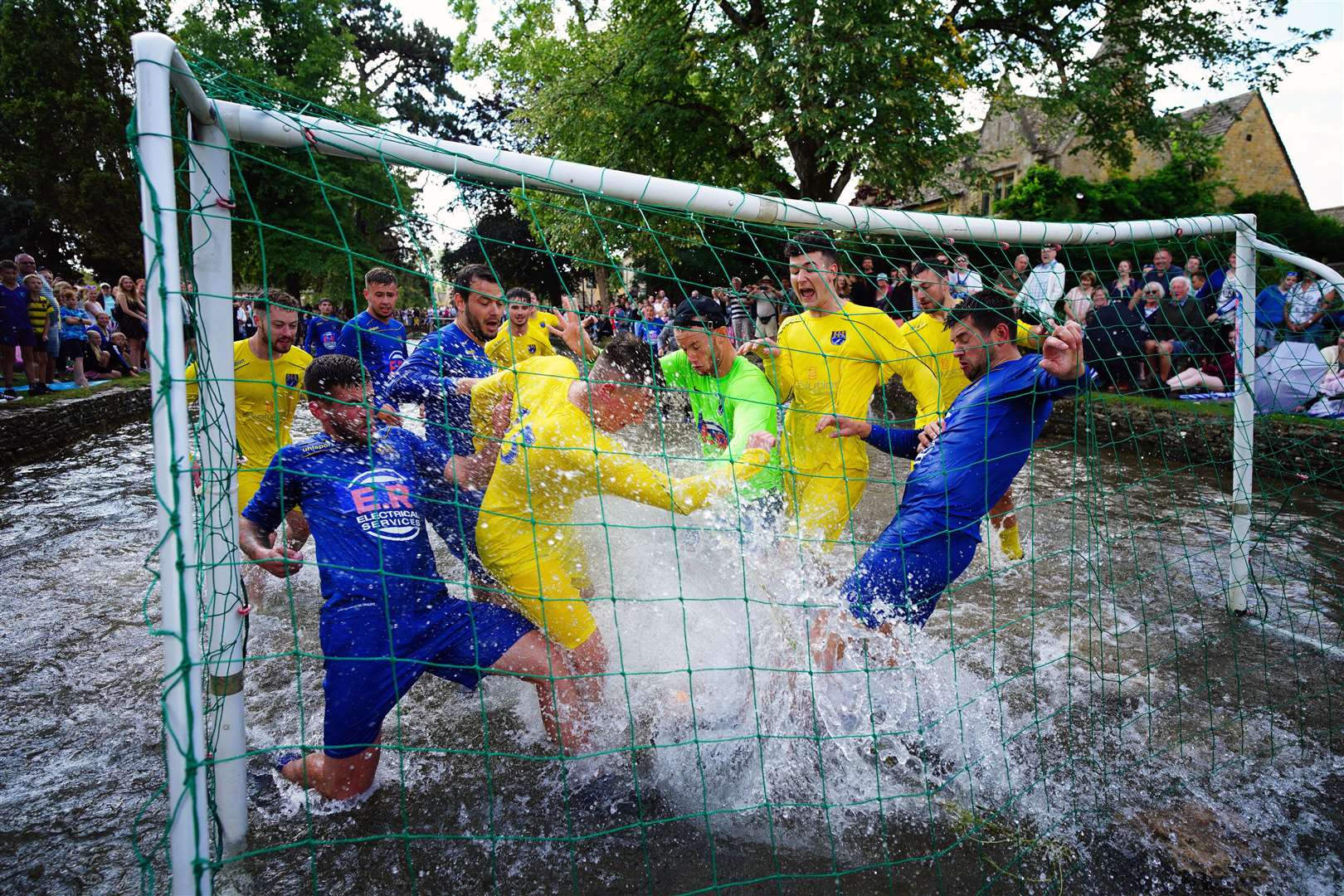 Footballers from Bourton Rovers go in deep as they fight for the ball (Ben Birchall/PA)
