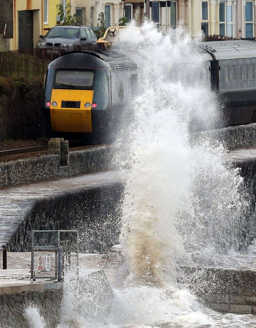 A train passes by strong waves in Dawlish, Devon, on Thursday (Steve Parsons/PA)
