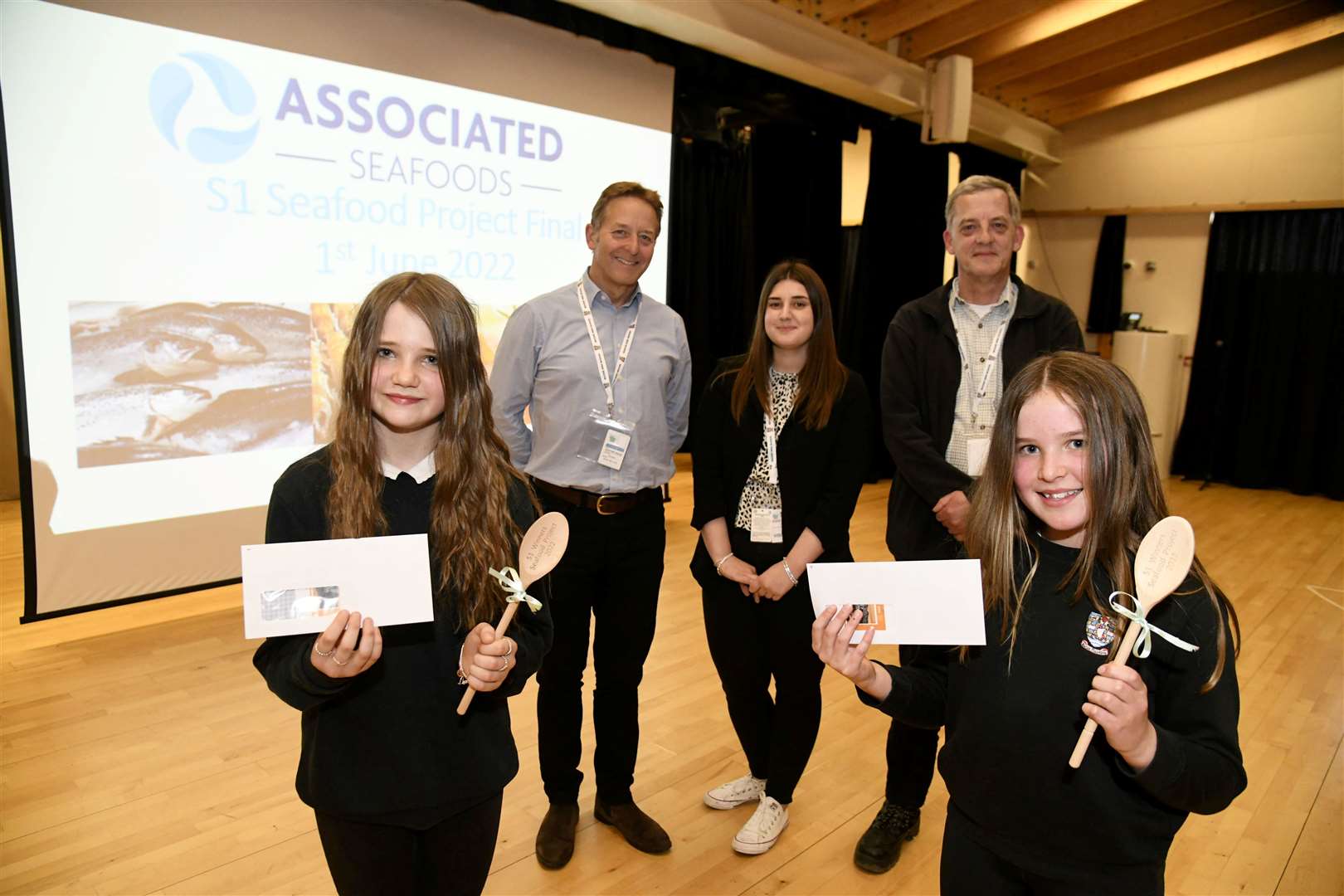 Seafood Project winners Seafield Seafoods – (left) Iona Smith and Skye Cameron – proudly display their winner's certificates, watched by judges (back from left) Henry Angus, Drew Niven and Jonathan Curtis. Picture: Becky Saunderson