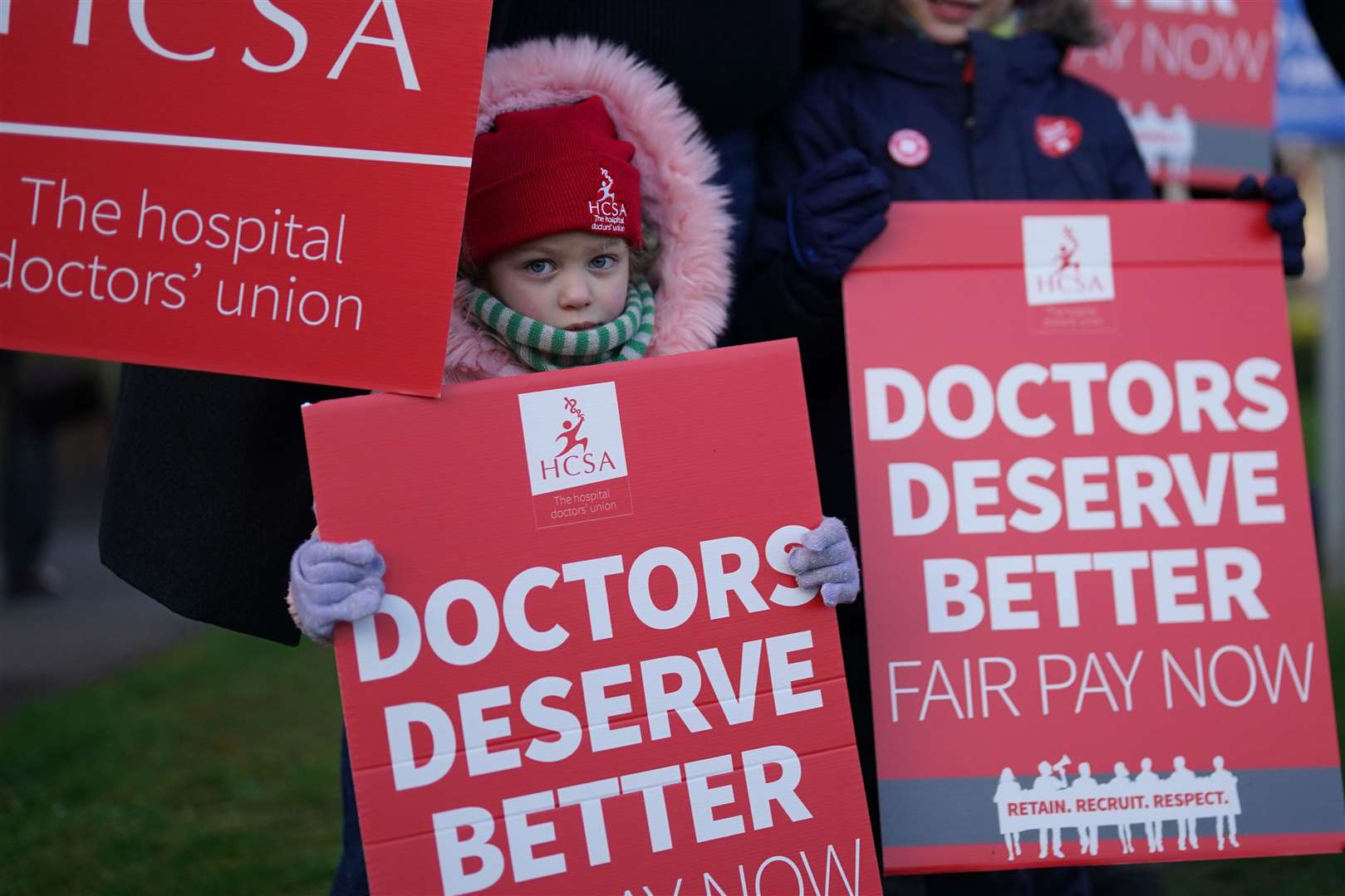 A child joins striking NHS junior doctors on the picket line outside Leicester Royal Infirmary (Jacob King/PA)