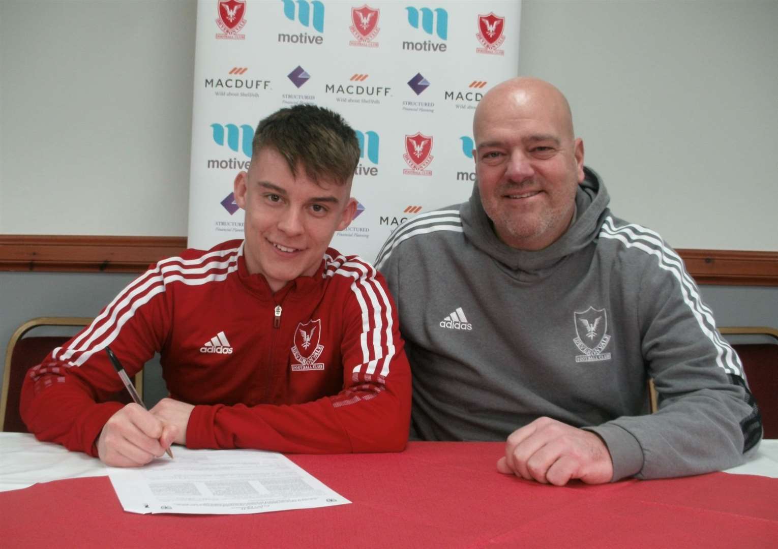 Mikey Watson puts pen to paper on a new deal with Deveronvale. Picture: Deveronvale Football Club