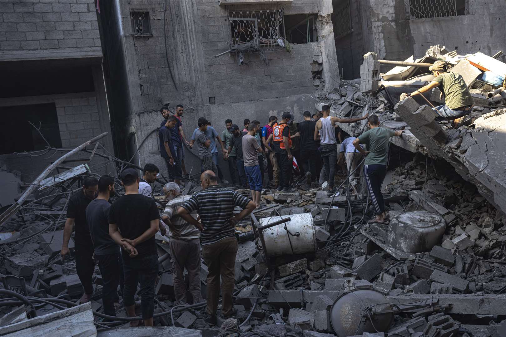 Palestinians search for bodies and survivors in the rubble of a residential building levelled in an Israeli airstrike at Al Shati Refugee Camp (Fatima Shbair/AP)