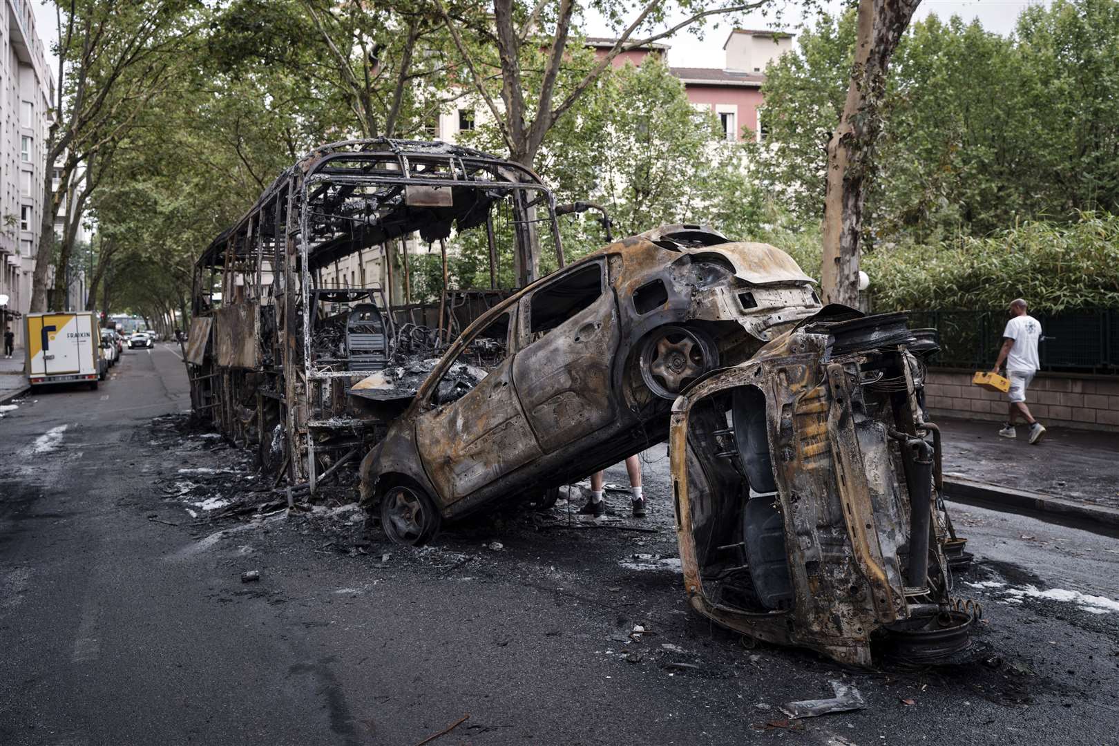 Charred cars and a bus in Lyon (Laurent Cipriani/AP)