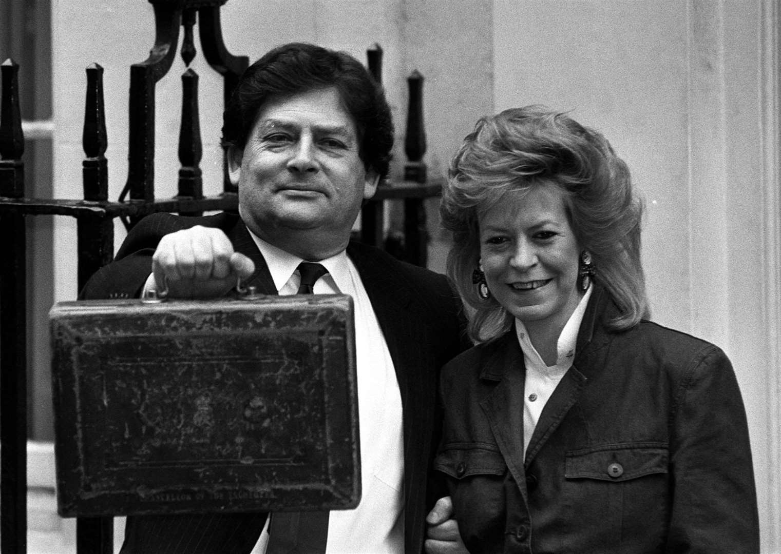 Nigel Lawson holding up his Budget box with his wife Therese (PA)