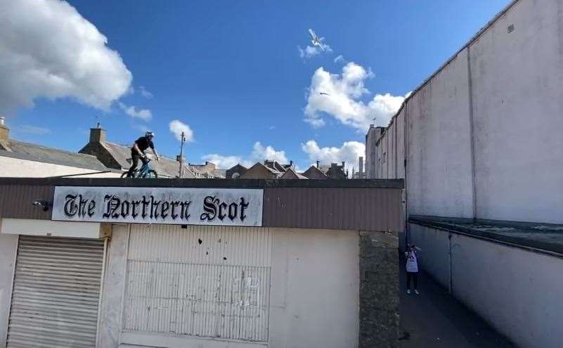 Danny MacAskill about to jump rooftops from the Northern Scot store building in Elgin.