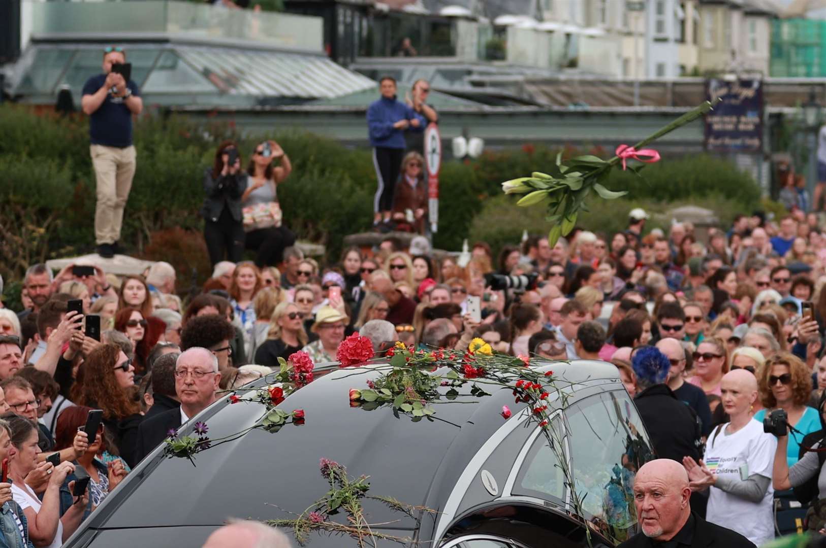Fans of singer Sinead O’Connor throw flowers on her hearse (Liam McBurney/PA)