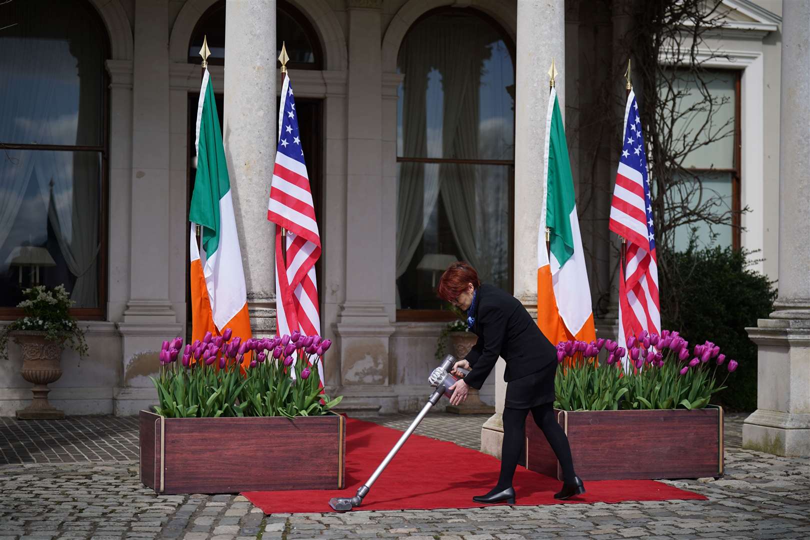 The red carpet gets a vacuum before Joe Biden’s arrival at Farmleigh House, Dublin, to meet Leo Varadkar (Niall Carson/PA)