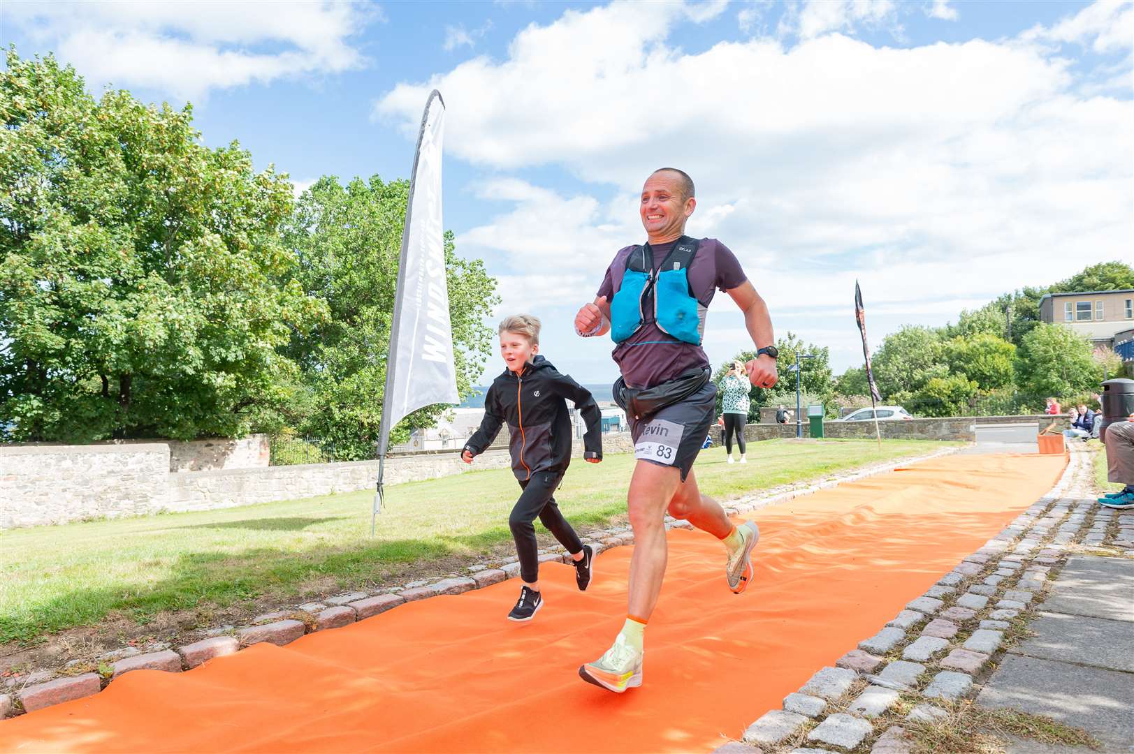 Kevin Mottram joined by his son at the finish. Photo: Angus Mclennan
