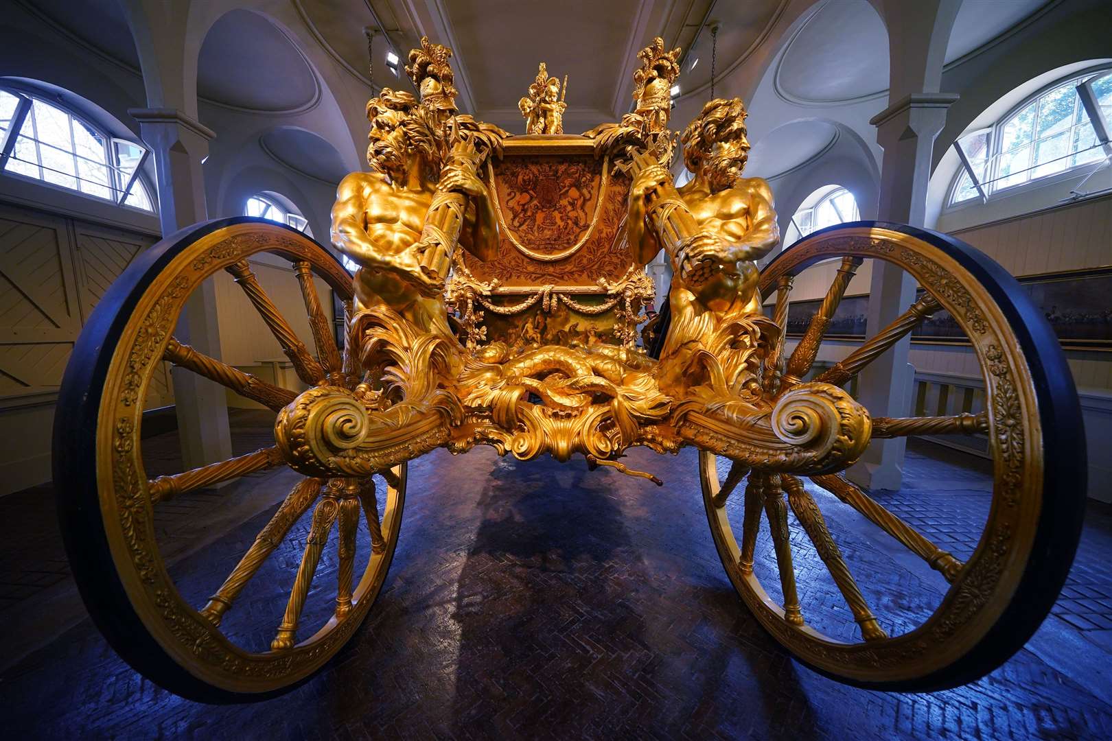 The Gold State Coach features, above each wheel, a massive triton figure in gilded walnut wood (Yui Mok/PA)