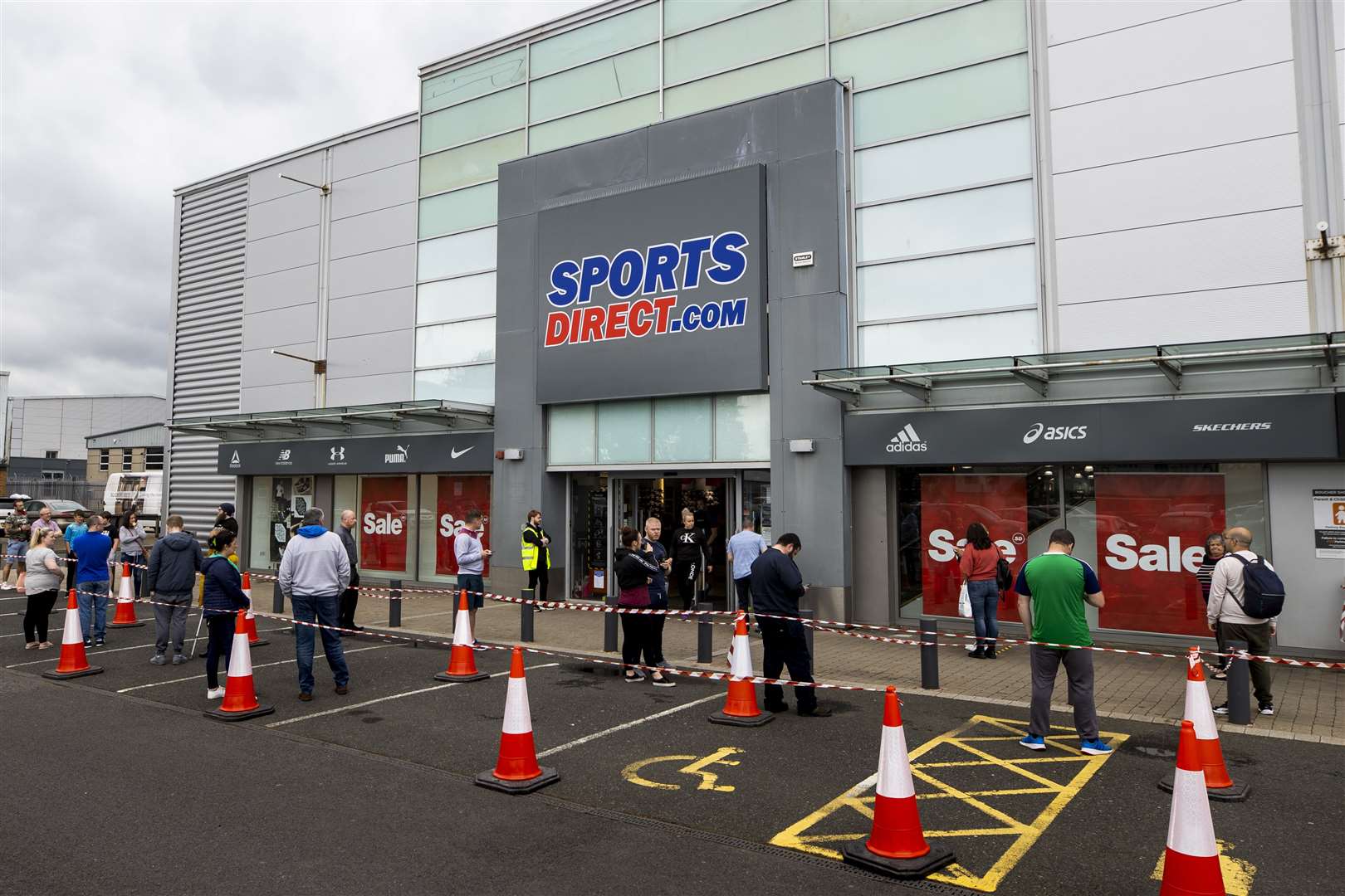Shoppers at a retail park in Belfast queue to enter Sports Direct after the store reopened (Liam McBurney/PA)