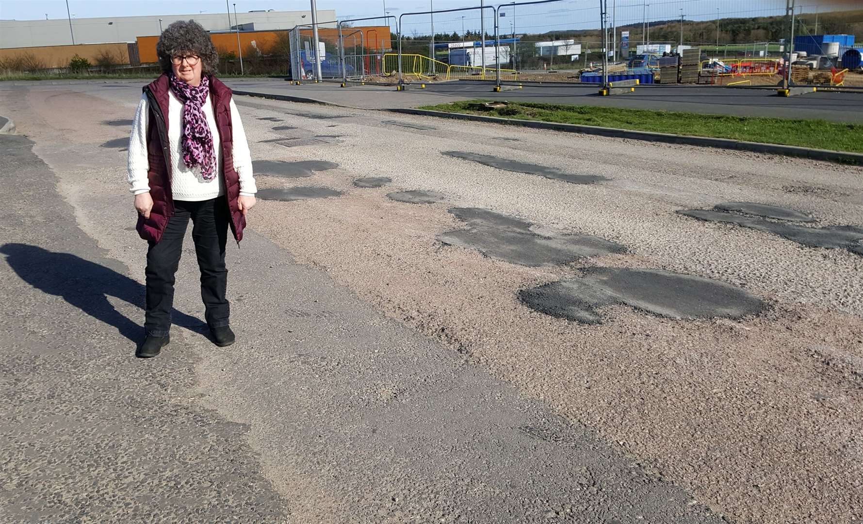 Gillian Owen shows the conditions of the roads at Balmacassie which are in need of work.