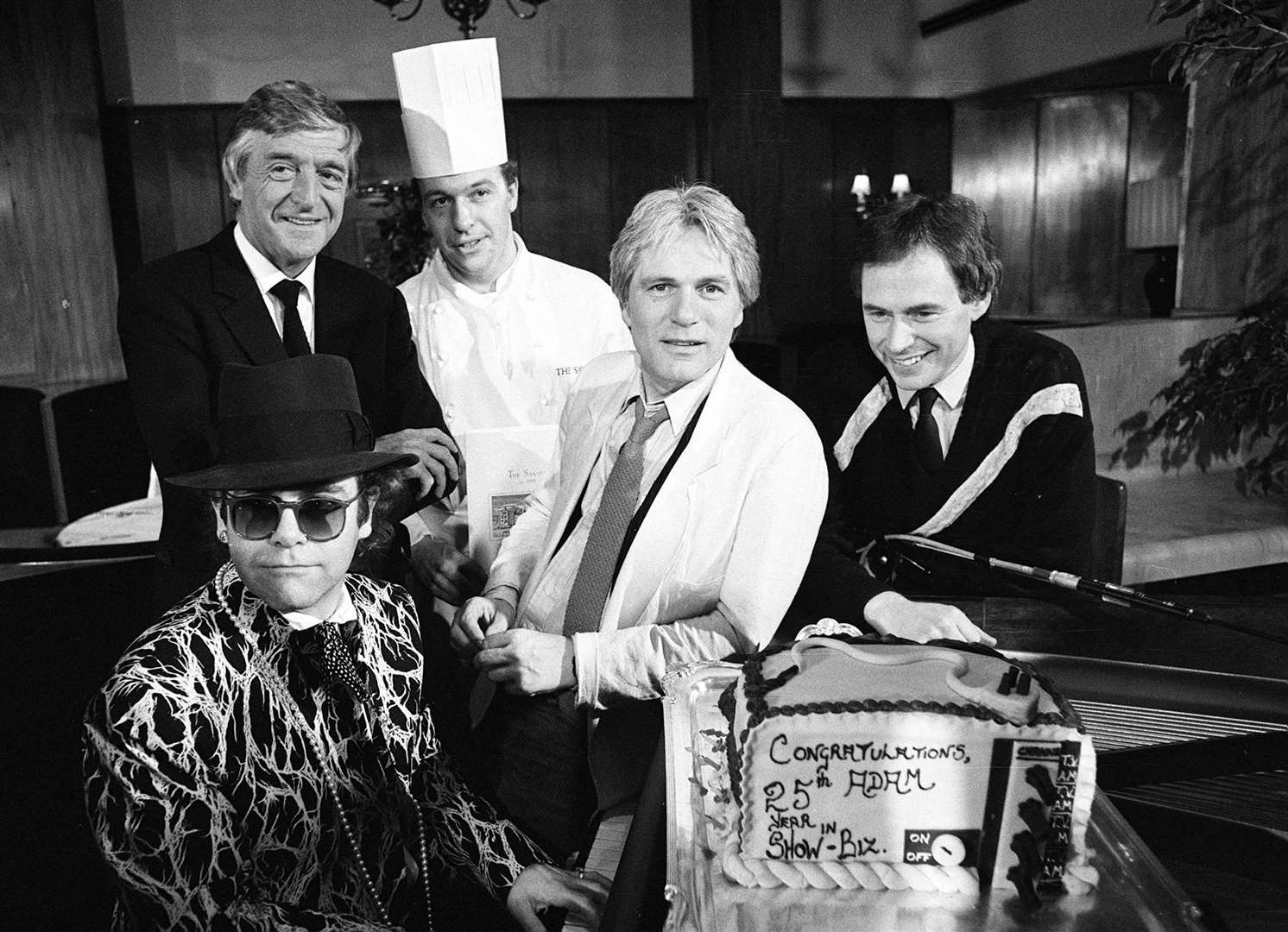 Singer Adam Faith (centre) celebrated 25 years in show business on TV-am with Sir Michael (standing left) and guests (PA)