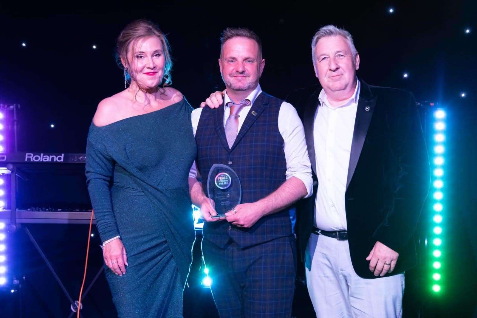 Councillor John Stuart (centre) receives his award from host Jane McCarry and John McPake from award sponsor Scotland's Railway. Picture: Proud Scotland