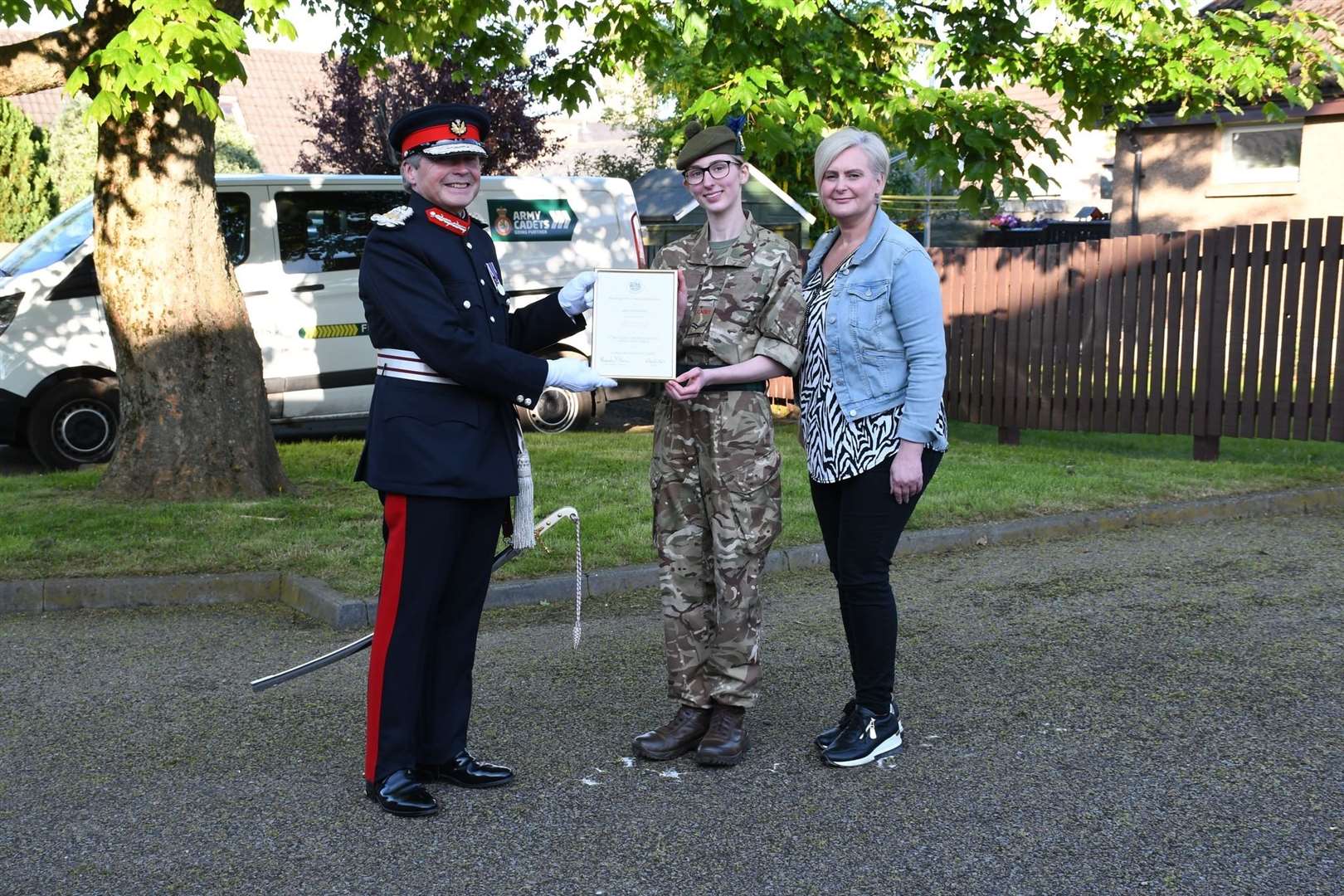 Corporal Stella Walker accepting her certificate from The Lord Lieutenant watched by a proud mum.