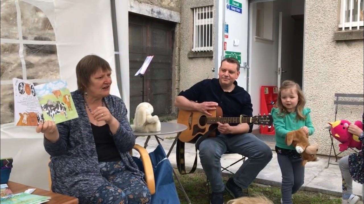 Jackie Ross reading Auld McDonald Hid a Fairm to families at Orbs Community Bookshop, accompanied by Aaron Gale (author and illustrator) and his daughter.