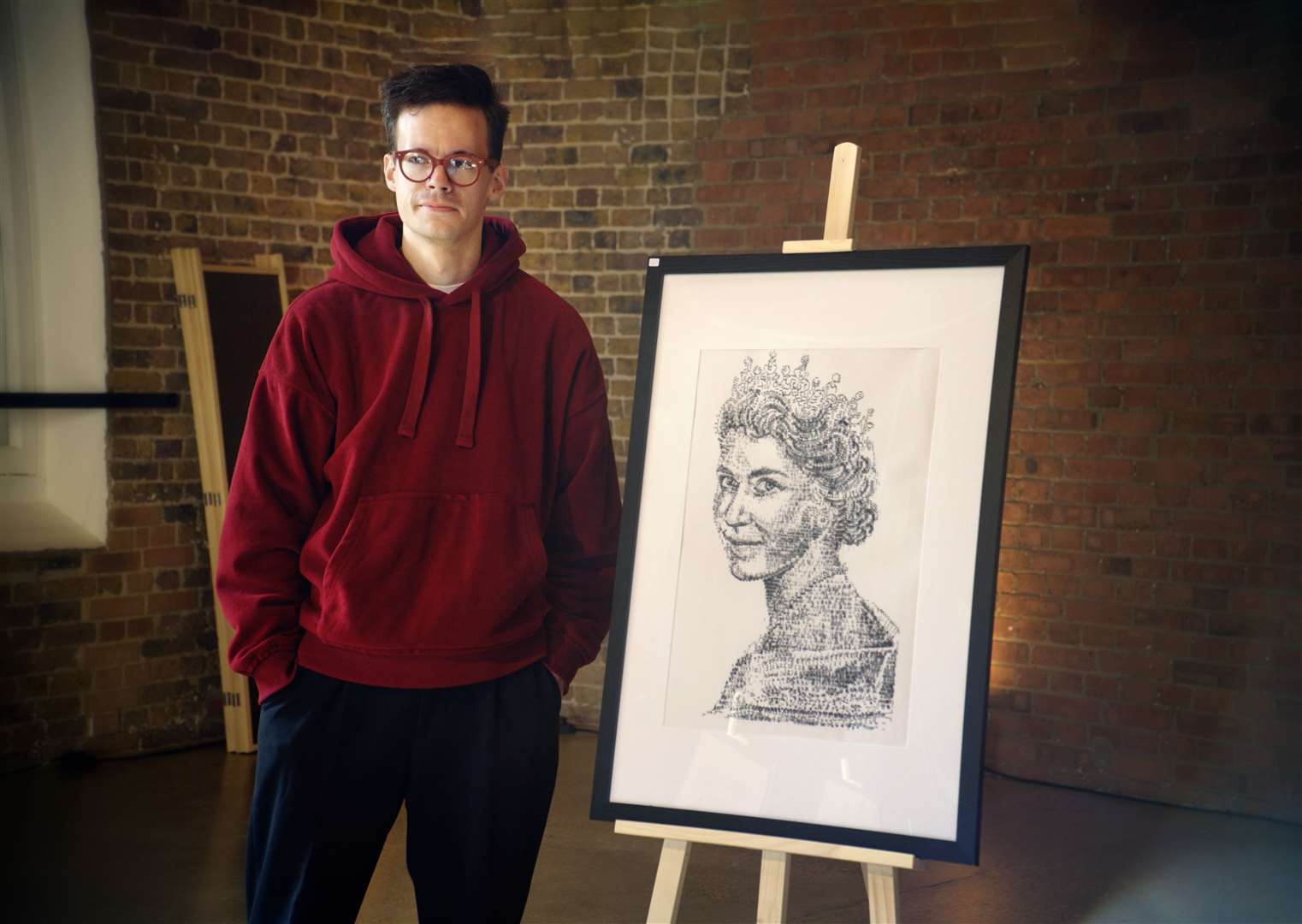 James Cook with a framed artwork of The Queen, which he drew (James Cook/PA)