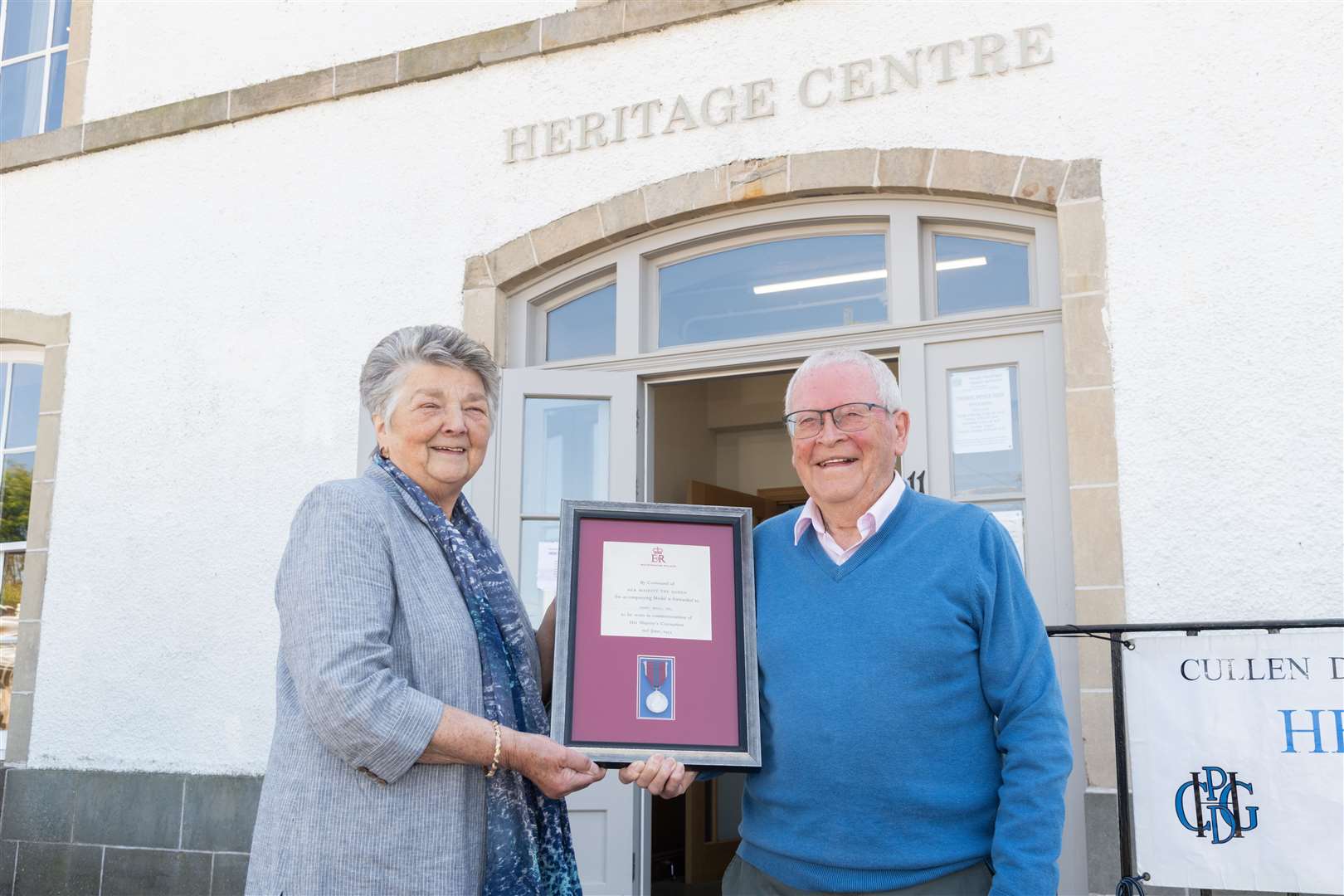 Joe Mowat presents his father's Queen Elizabeth coronation medal to Cullen, Deskford and Portknockie Heritage Group president Brenda Wood.. Picture: Beth Taylor