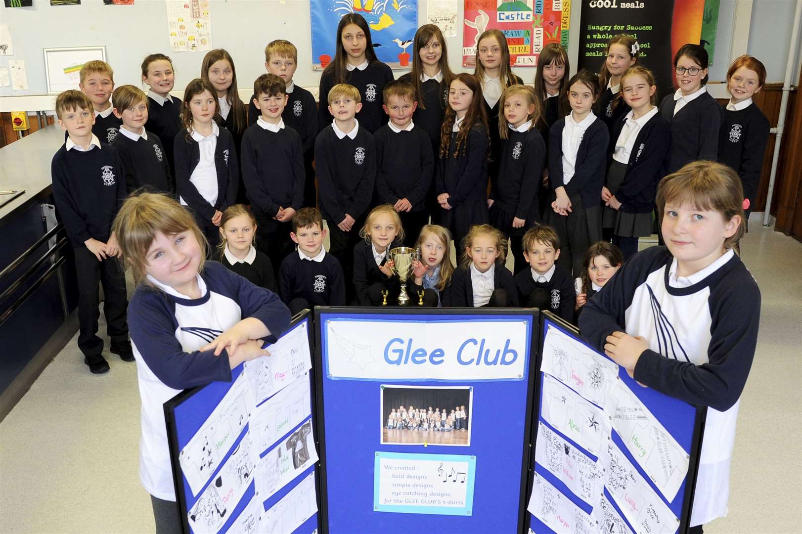 Victory Glee...Glee Club members Faith Miller (front left) and Rhianna McMillan show off the choir's specially made competitive T-shirts as the other singers display the Moray Schools Glee trophy. Picture: Eric Cormack