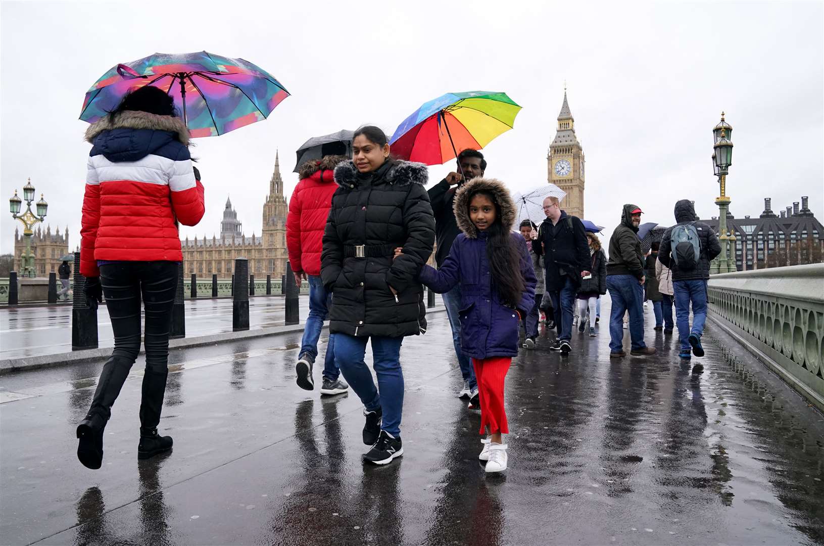 People brave the rainy conditions on Westminster Bridge, London last week (PA)