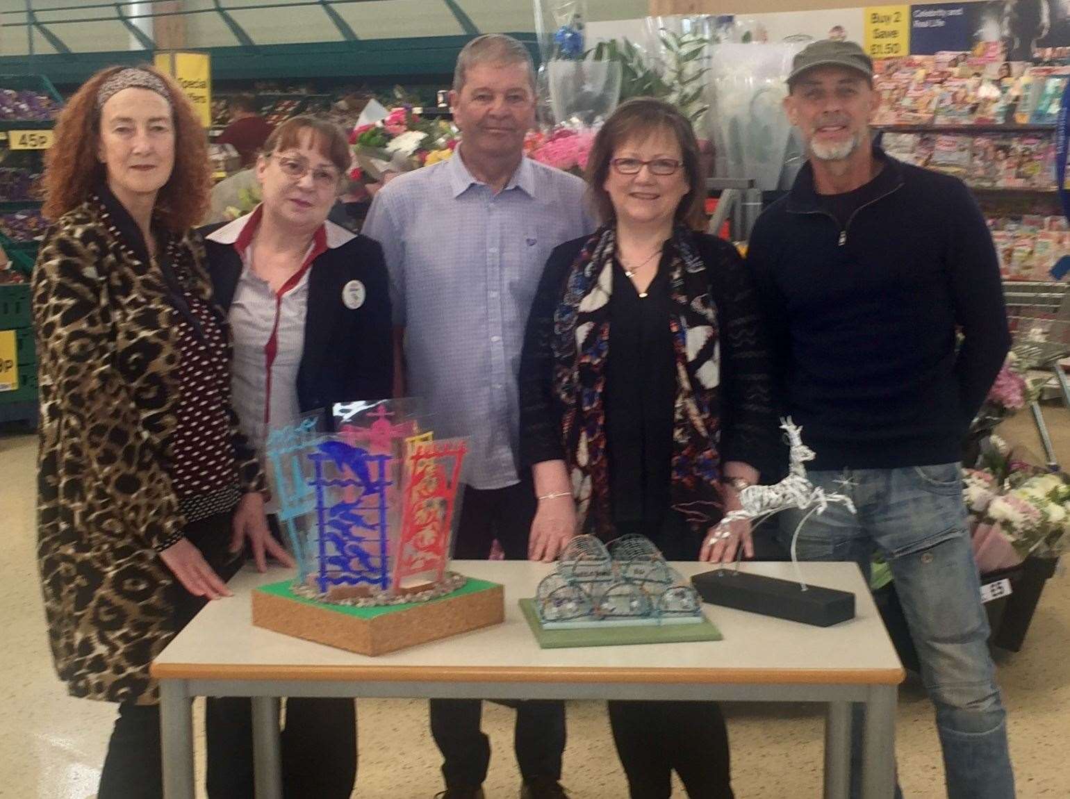 Artists Maggie Clyde (left) and Carn Standing (right) show off their designs to Councillors Gordon Cowie and Sonya warren (second right), joined by Tesco checkout manager Gillian Bower. Missing from the photo is artist Emma Crawford. Photo: SPP