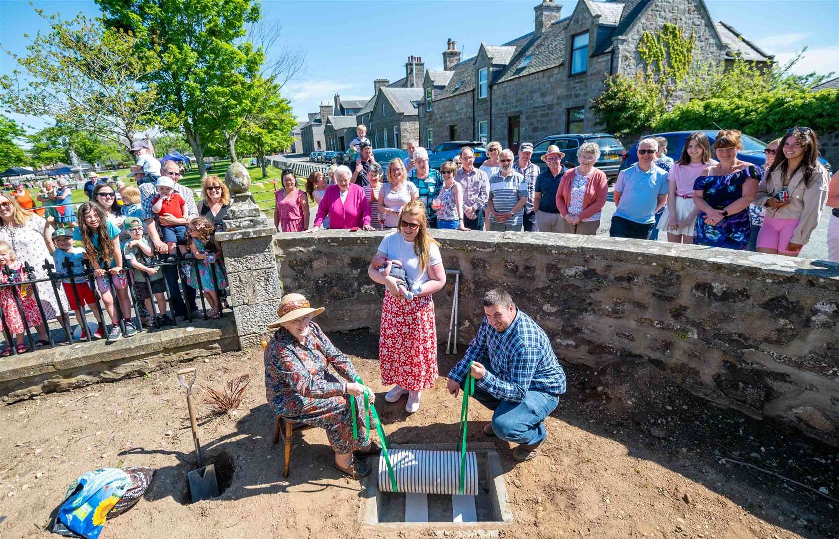 Spanning the generations as a time capsule is buried in the garden at Rhynie Church as part of the jubilee events. Picture: Michael Traill.