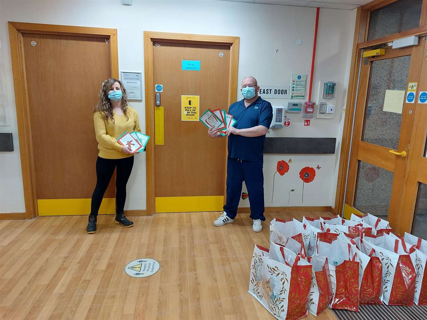Megan Walls hands over gifts to Muirton Ward manager Craig Higgins for the patients there. Picture: Friends of Seafield Hospital