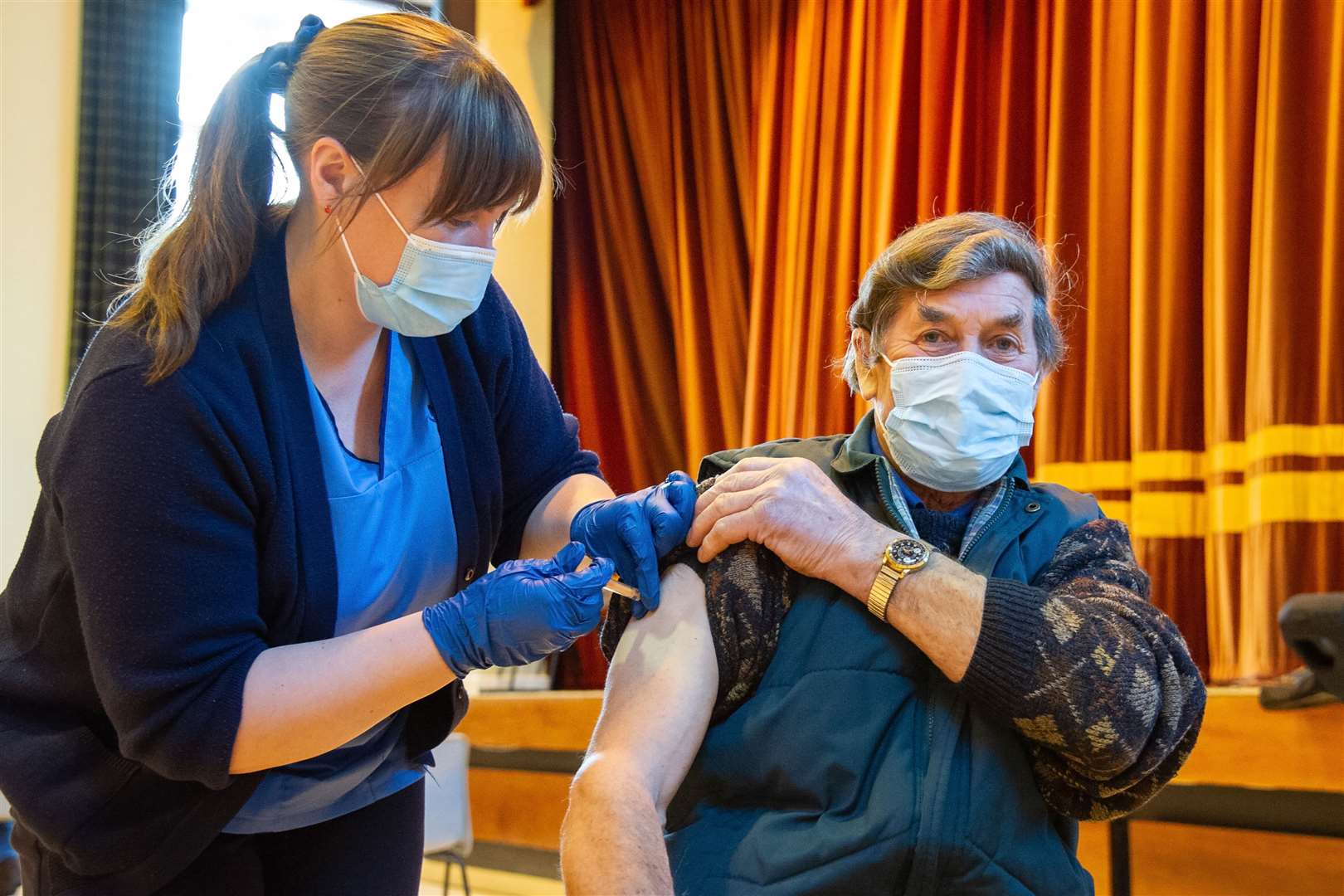 Ian Stewart receives his vaccine from Karen Law at he vaccination hub in the Stewart's Hal. Picture: Daniel Forsyth.